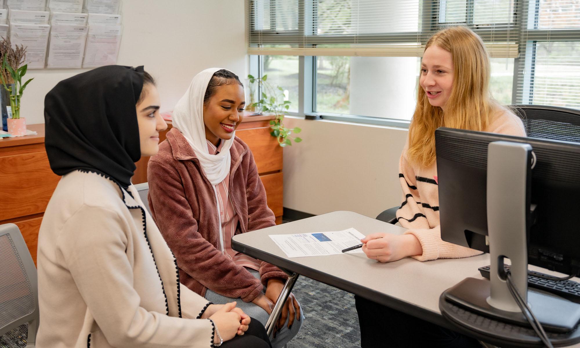 two students meeting with an advisor